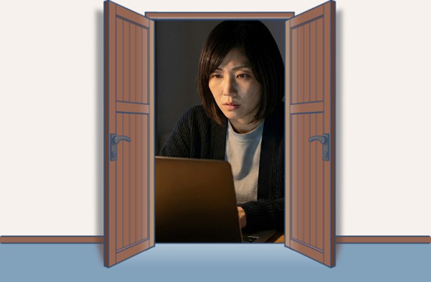 夜の自宅でノートパソコンに向かい、真剣な表情で情報を確認している女性レーシングチームマネージャーの姿。