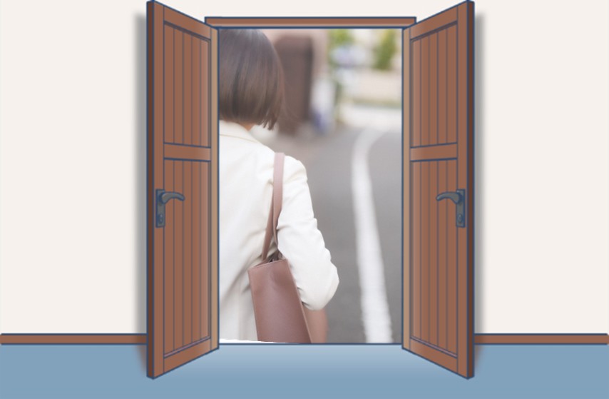 バッグを持って前を向いて歩く女性の後ろ姿